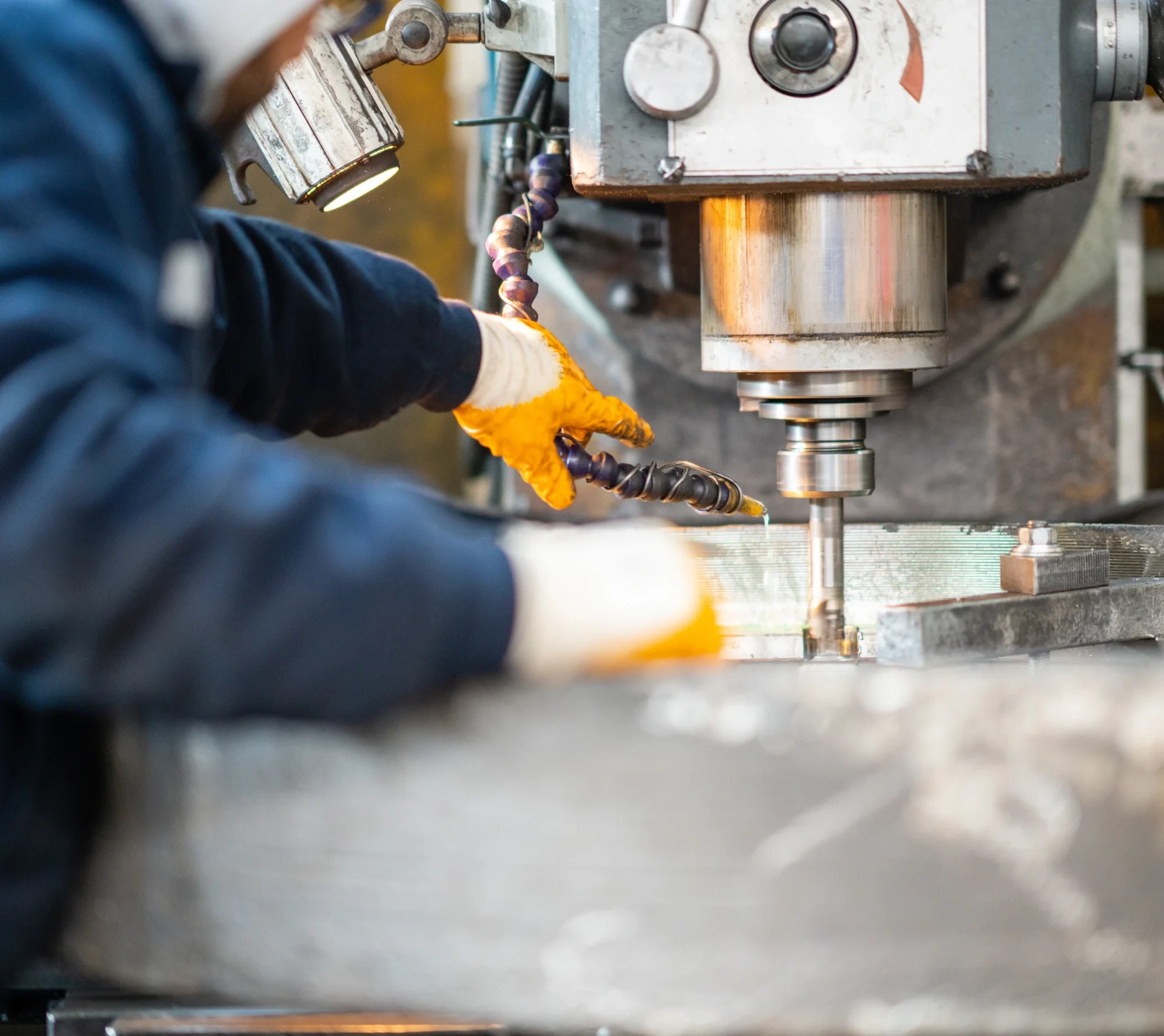 Worker operating industrial drilling machine